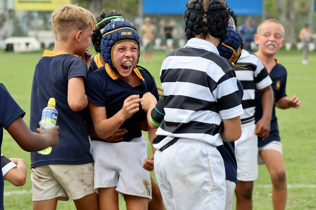 Young boys in rugby gear celebrating on field